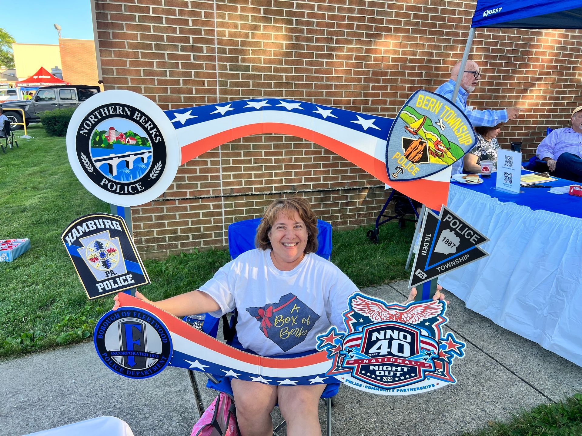 A woman is sitting in a chair holding a sign that says nmc 40.