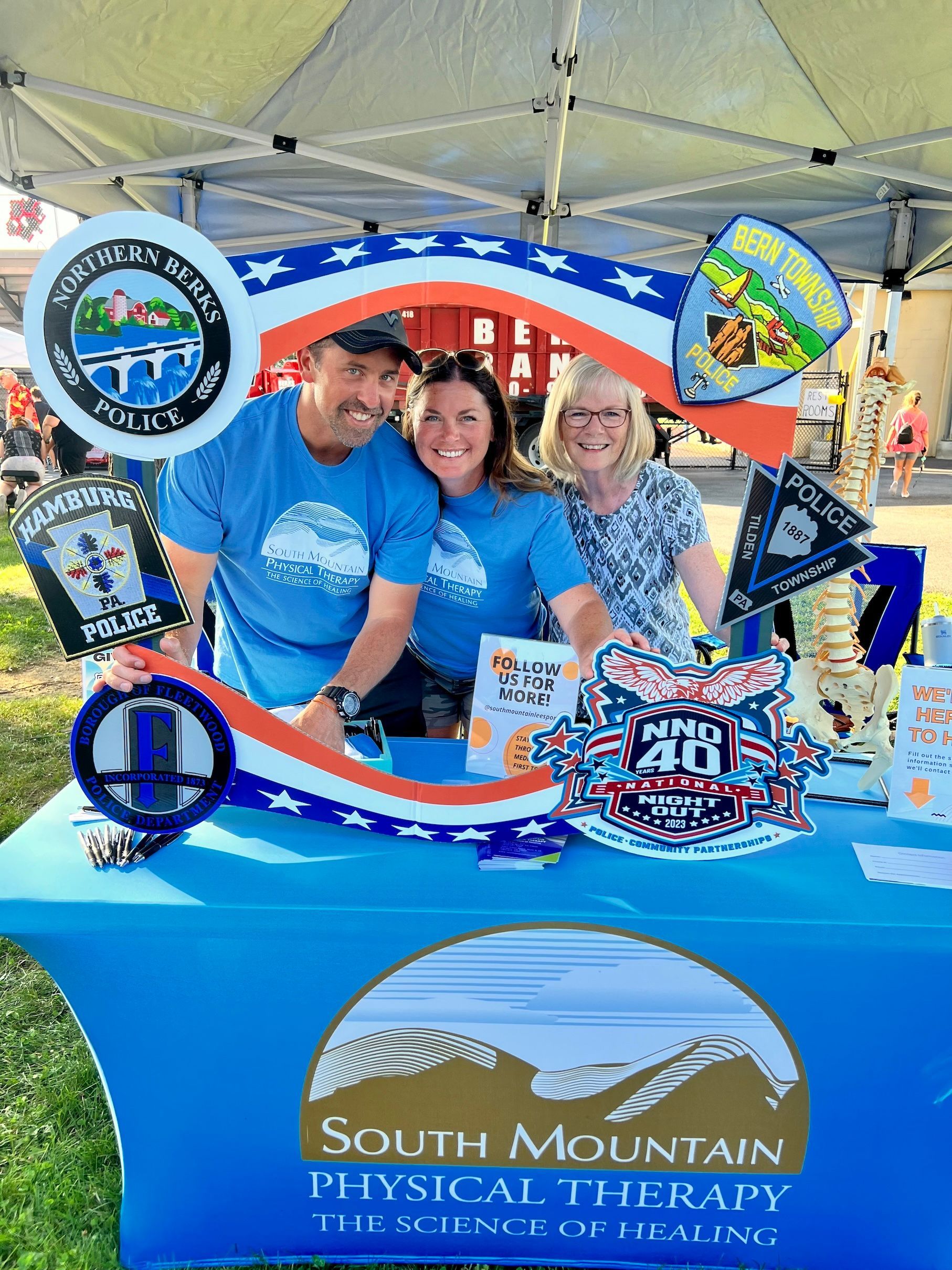 A group of people are posing for a picture at a south mountain physical therapy booth.