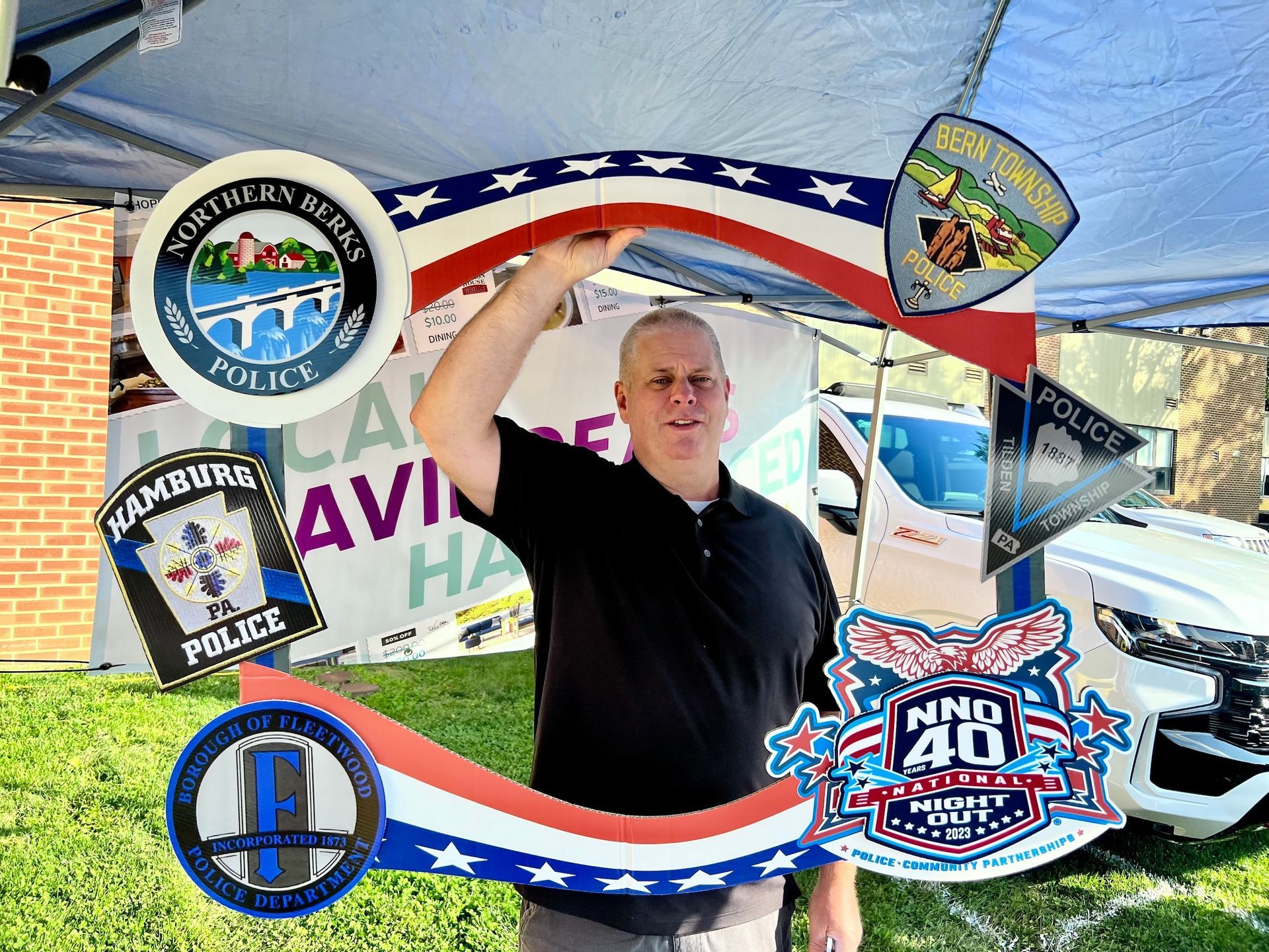 A man is standing in front of a tent with a sign that says police on it.