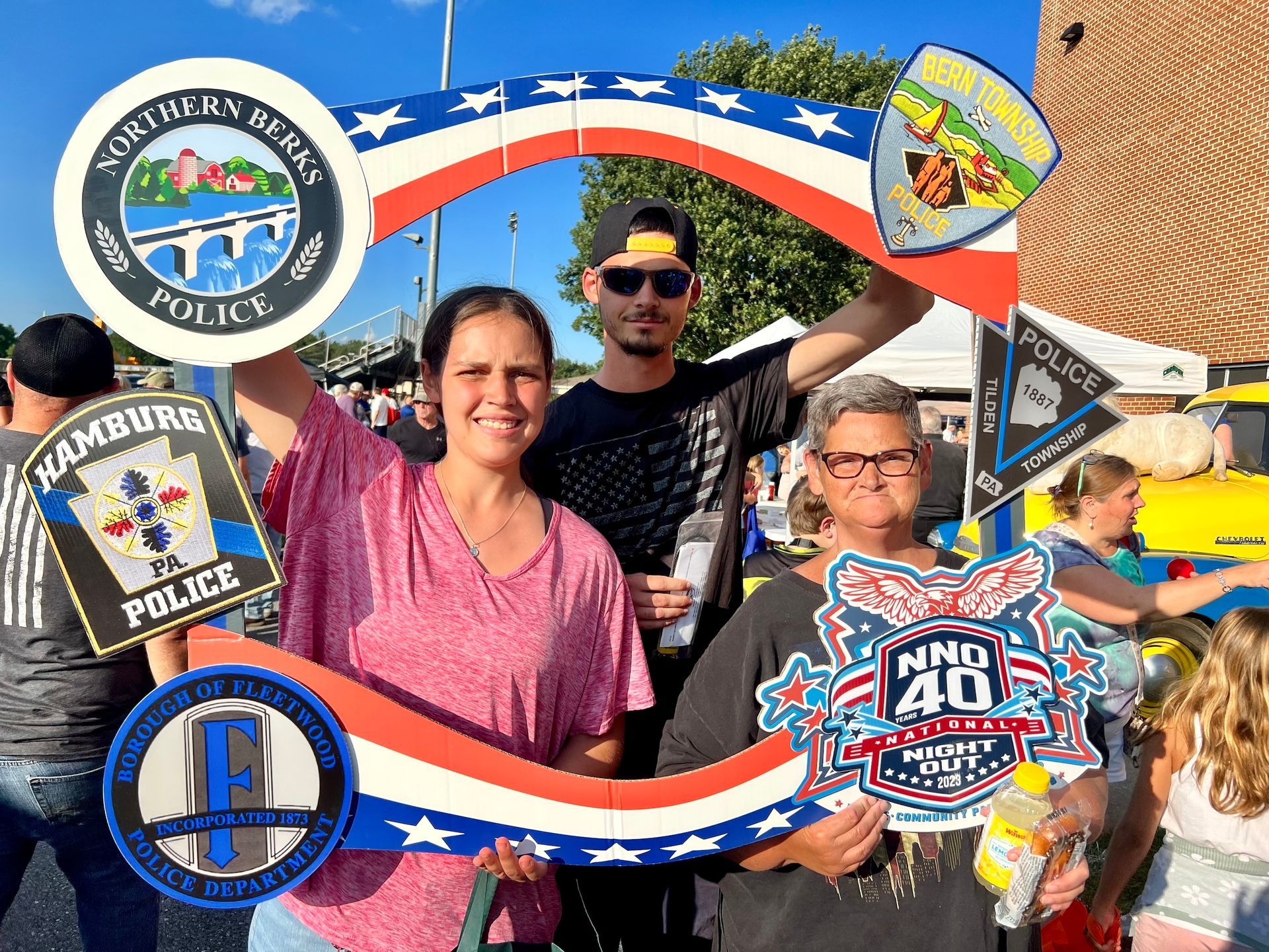 A group of people are posing for a picture with a picture frame.