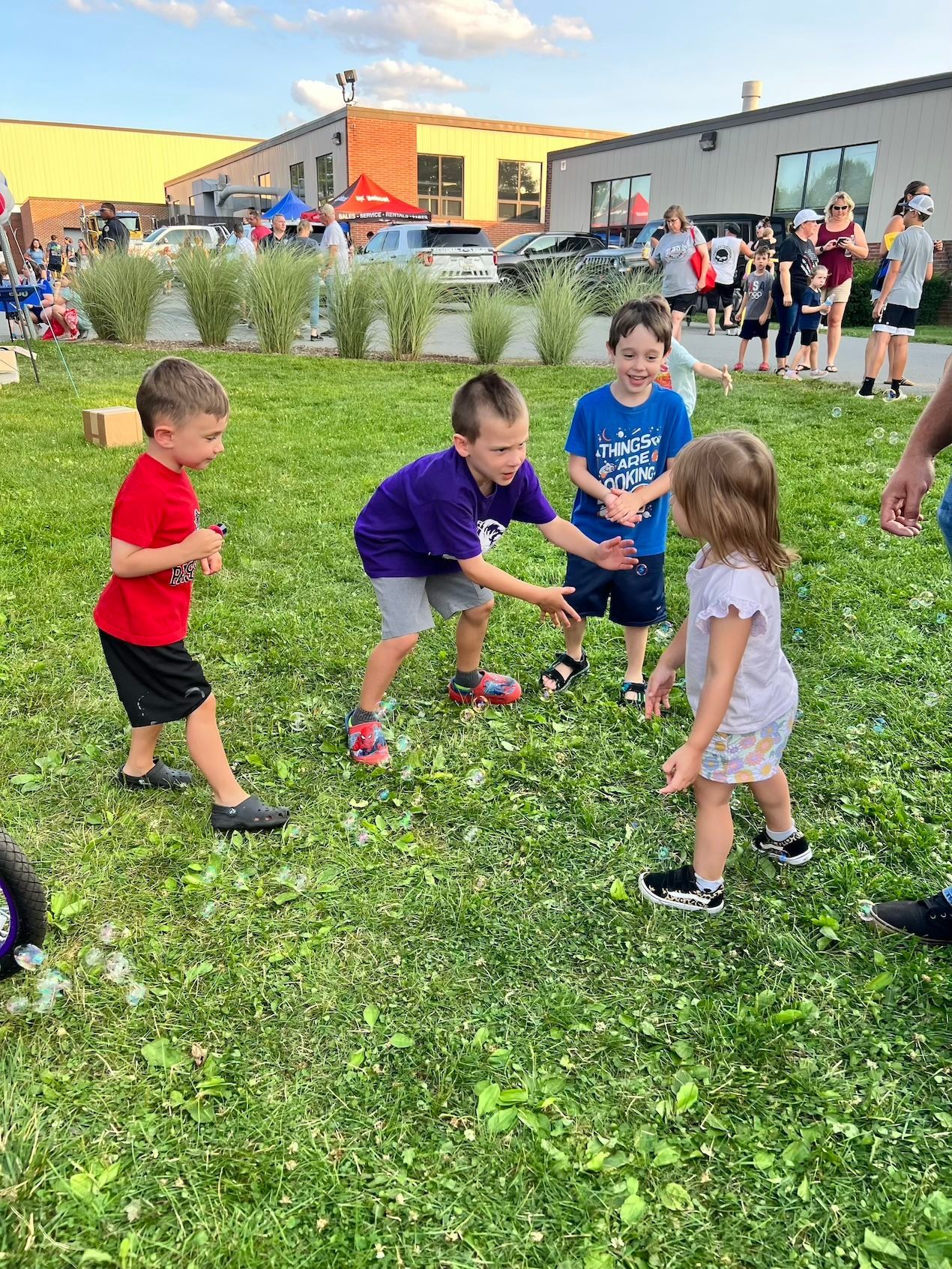 A group of children are playing in a grassy field.