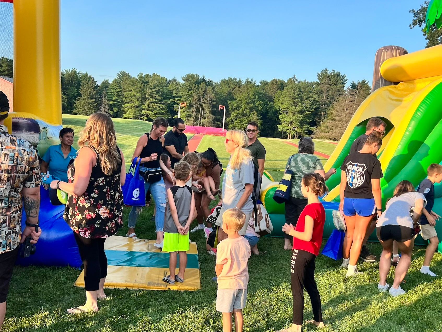 A group of people are standing in front of a bouncy house.