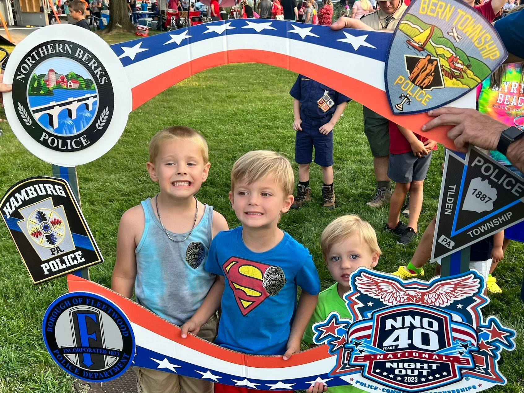 A group of young boys are posing for a picture in front of a police sign.