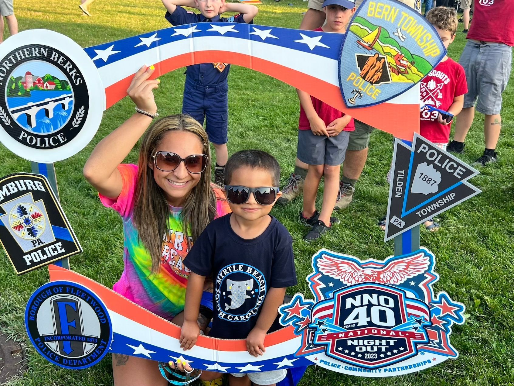 A woman and a child are posing for a picture in front of a sign that says police.