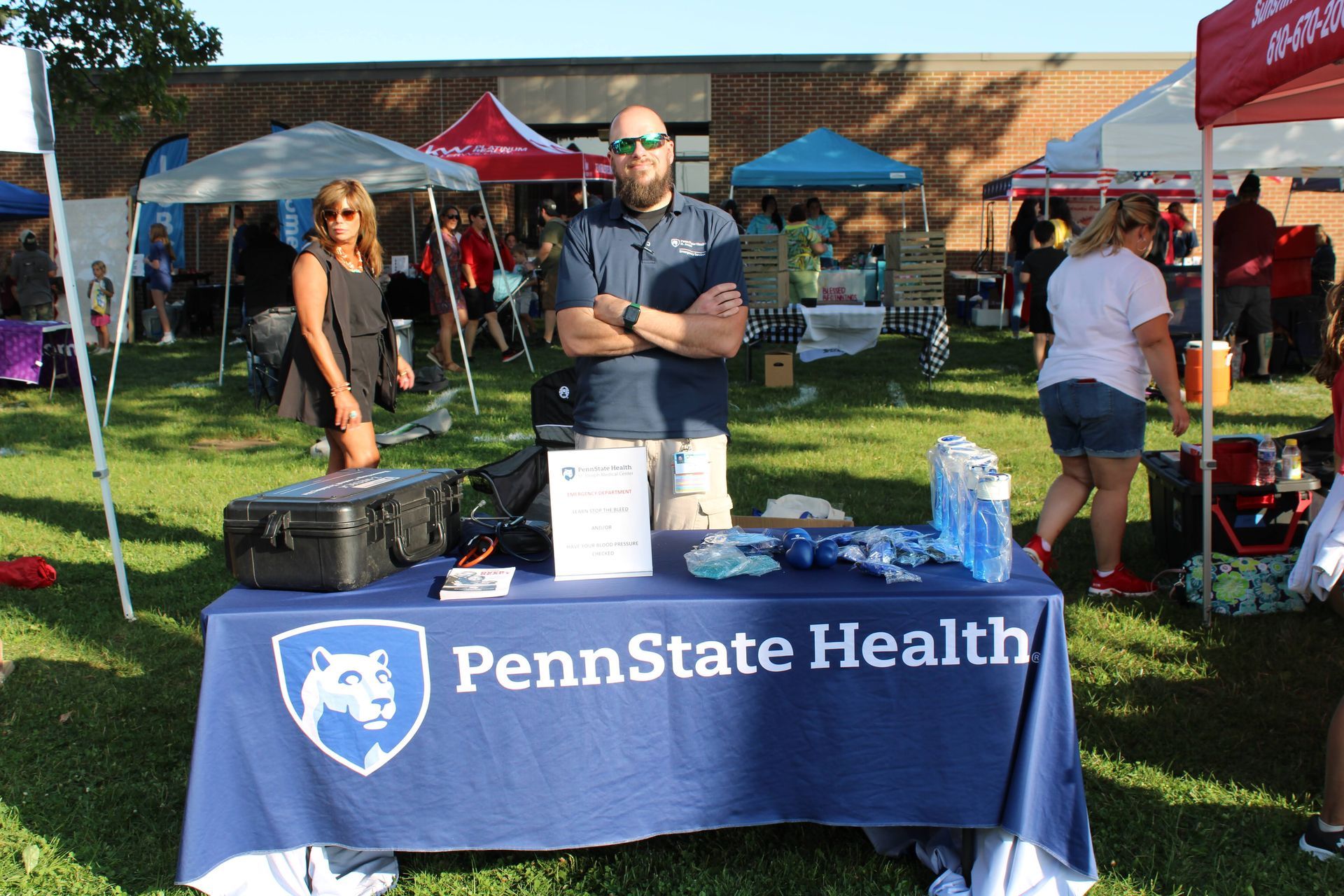 A man stands in front of a penn state health table