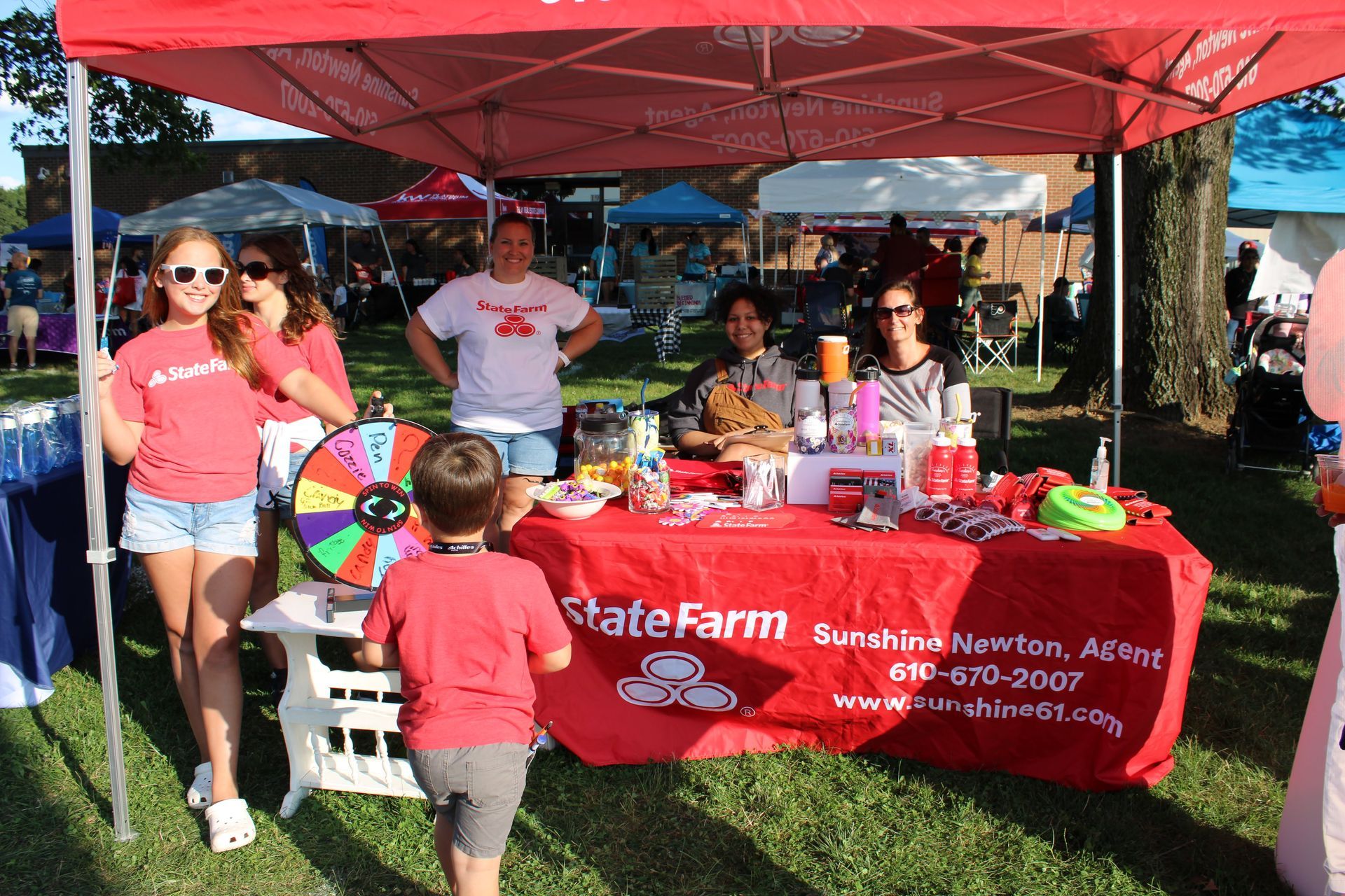 A group of people standing around a table that says state farm
