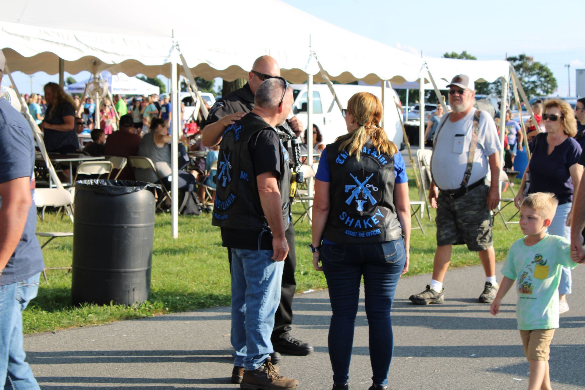 A group of people are standing under a tent.