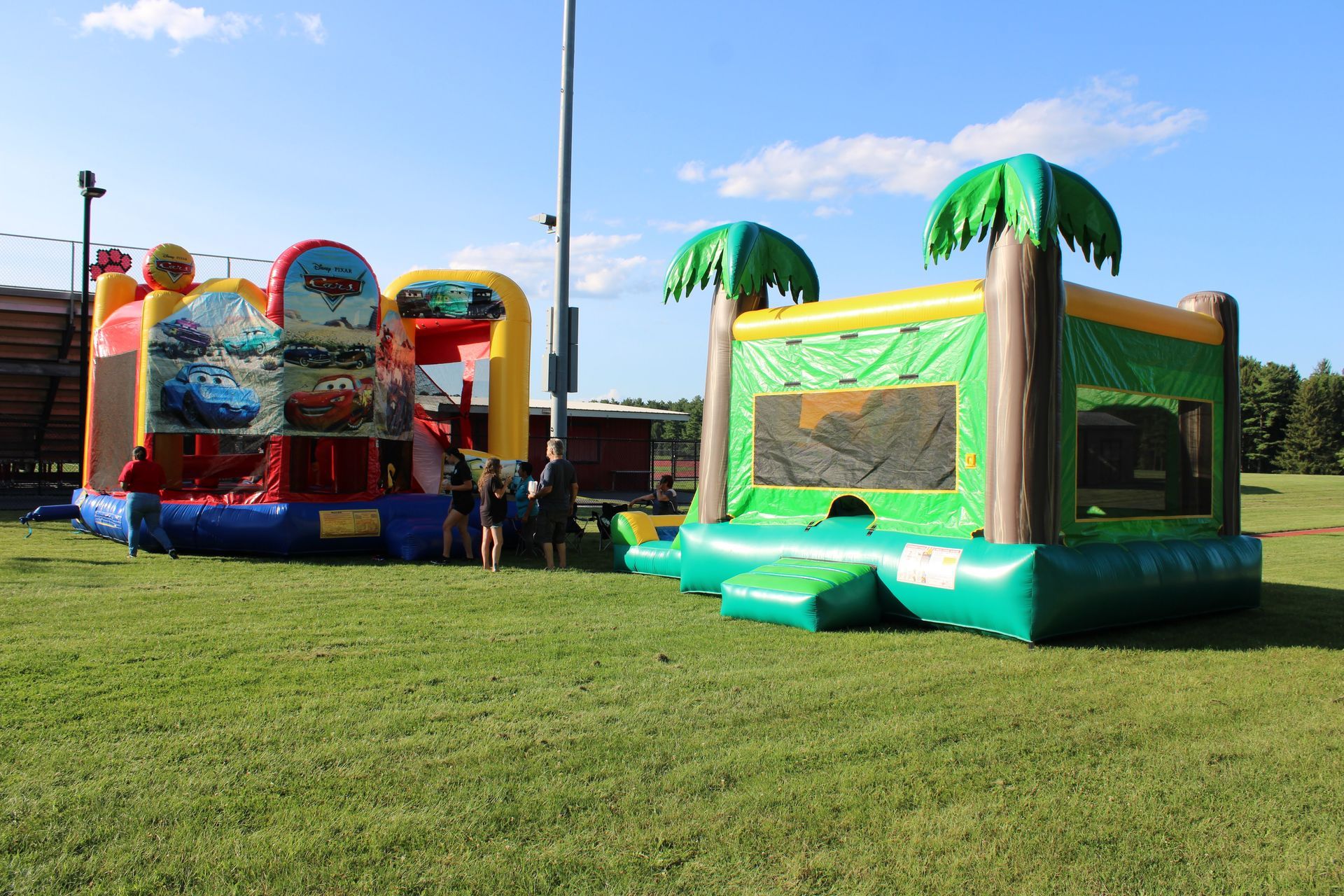 A couple of bouncy houses sitting on top of a lush green field.