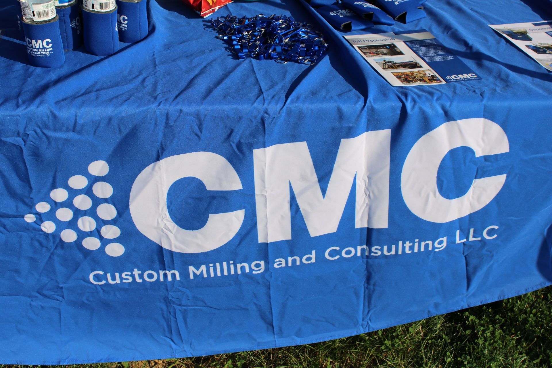 A blue table cloth with cmc custom milling and consulting llc written on it