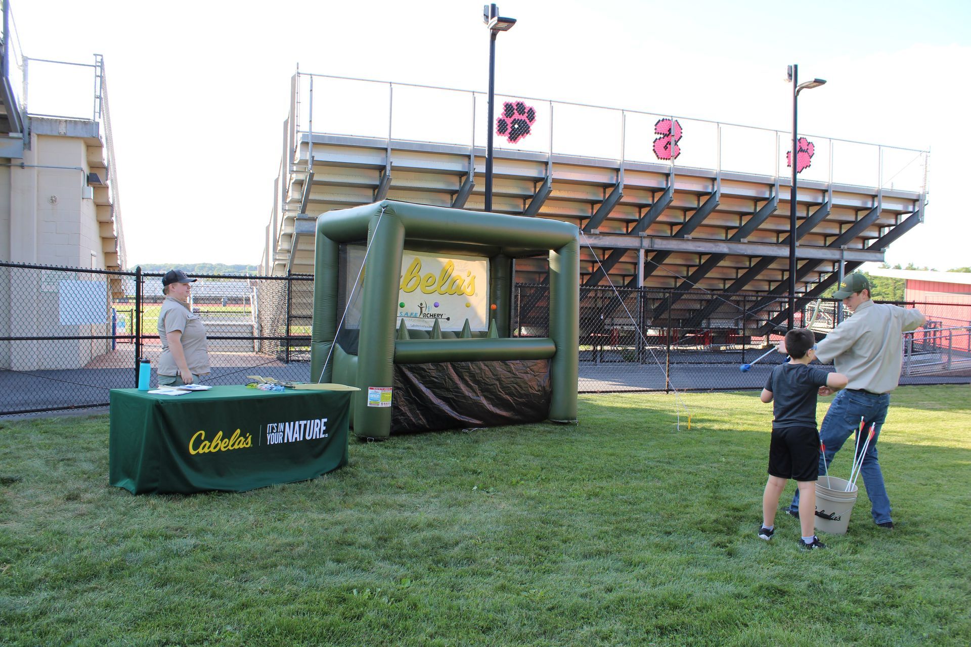 A man and a boy are playing a game in front of a stadium.