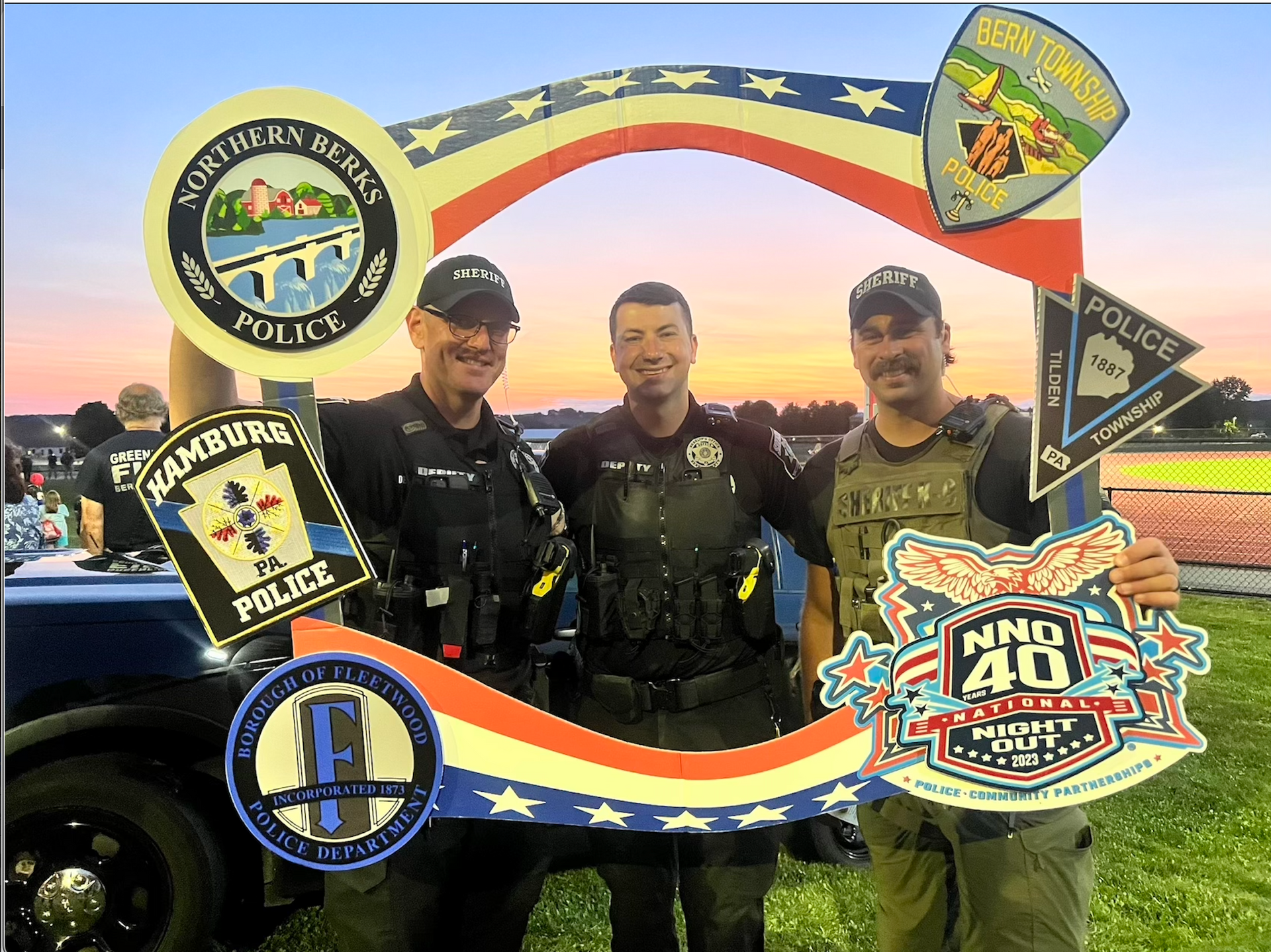 A group of police officers are posing for a picture in front of a sign that says hamburg police