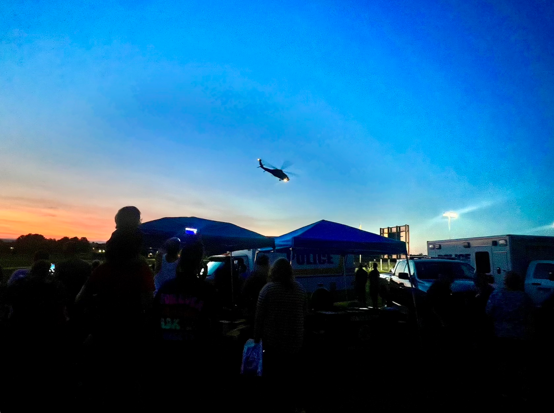 A helicopter is flying over a crowd of people