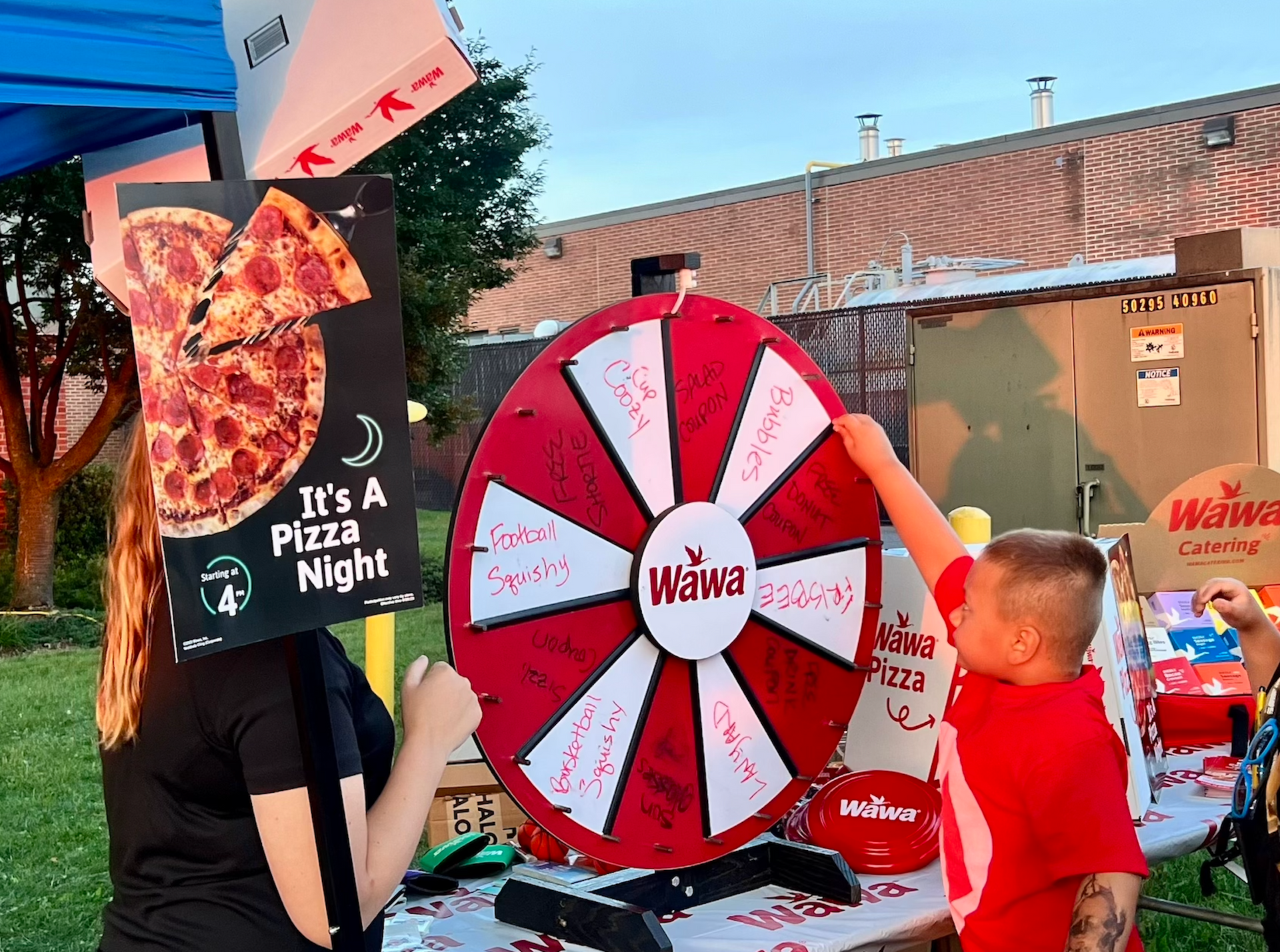 A woman is holding a sign that says it 's a pizza night.