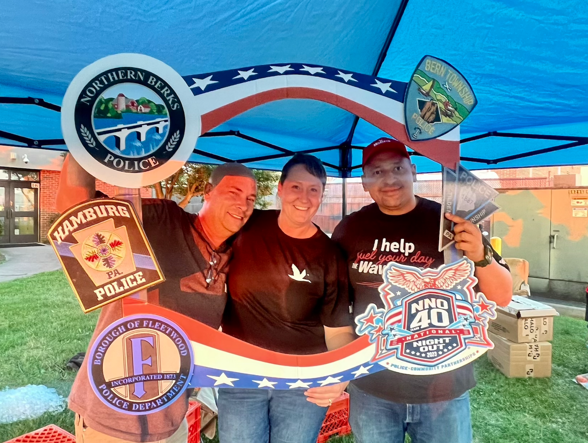 A group of people are posing for a picture under a tent.