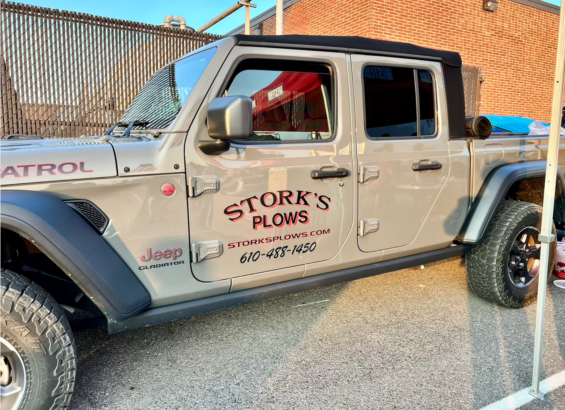 A storm 's plows truck is parked in a parking lot