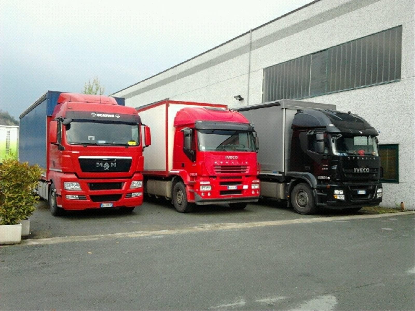 Tre camion sono parcheggiati davanti a un edificio