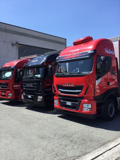 Una fila di camion rossi sono parcheggiati in un parcheggio.