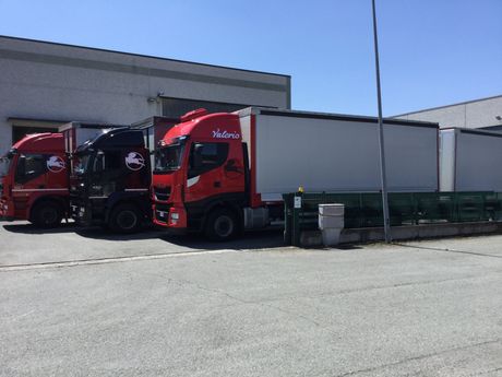 Tre camion rossi sono parcheggiati davanti a un edificio.