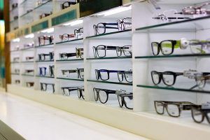Eyeglass frames on display in a well-lit optical shop.