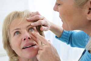 Woman having her eye examined by another woman.