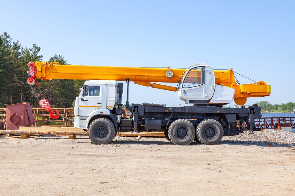 A Yellow Crane is Parked on the Side of a Truck — BS Crane Truck and Trailer Hire In Eumundi, QLD