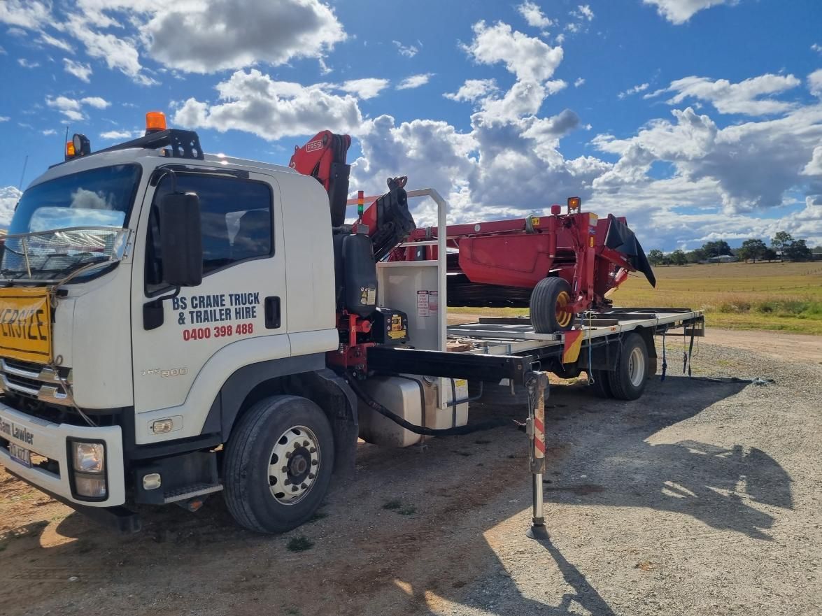 A Tow Truck With a Crane on the Back is Parked in a Gravel Lot — BS Crane Truck and Trailer Hire In Cooroy, QLD
