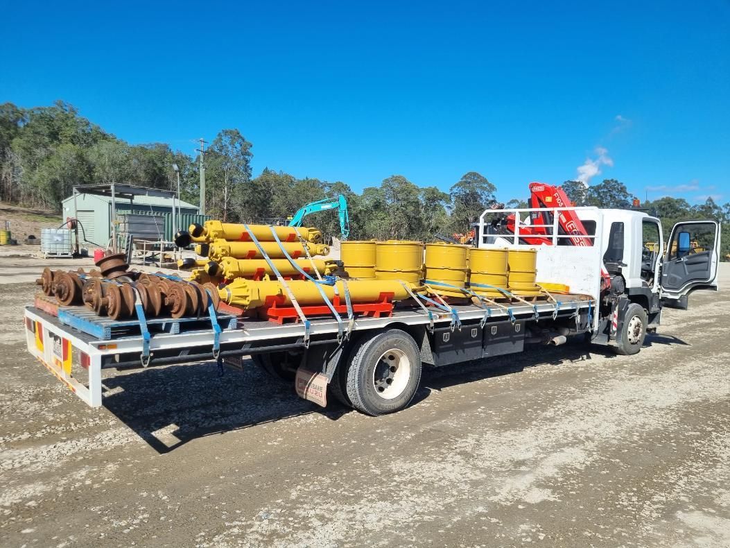 A Truck is Loaded With Barrels and Pipes on the Back of It — BS Crane Truck and Trailer Hire In Buderim, QLD