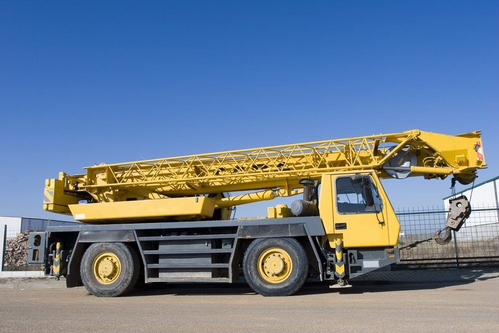 A Yellow Crane Truck is Parked in a Parking Lot — BS Crane Truck and Trailer Hire In Eumundi, QLD