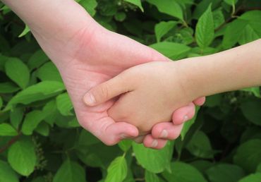 Child and adult holding hands