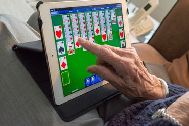 Person playing solitaire on tablet device