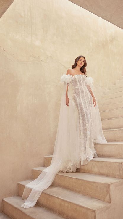 A woman in a wedding dress is standing on a set of stairs.