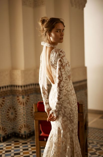 A woman in a wedding dress is standing on a set of stairs.