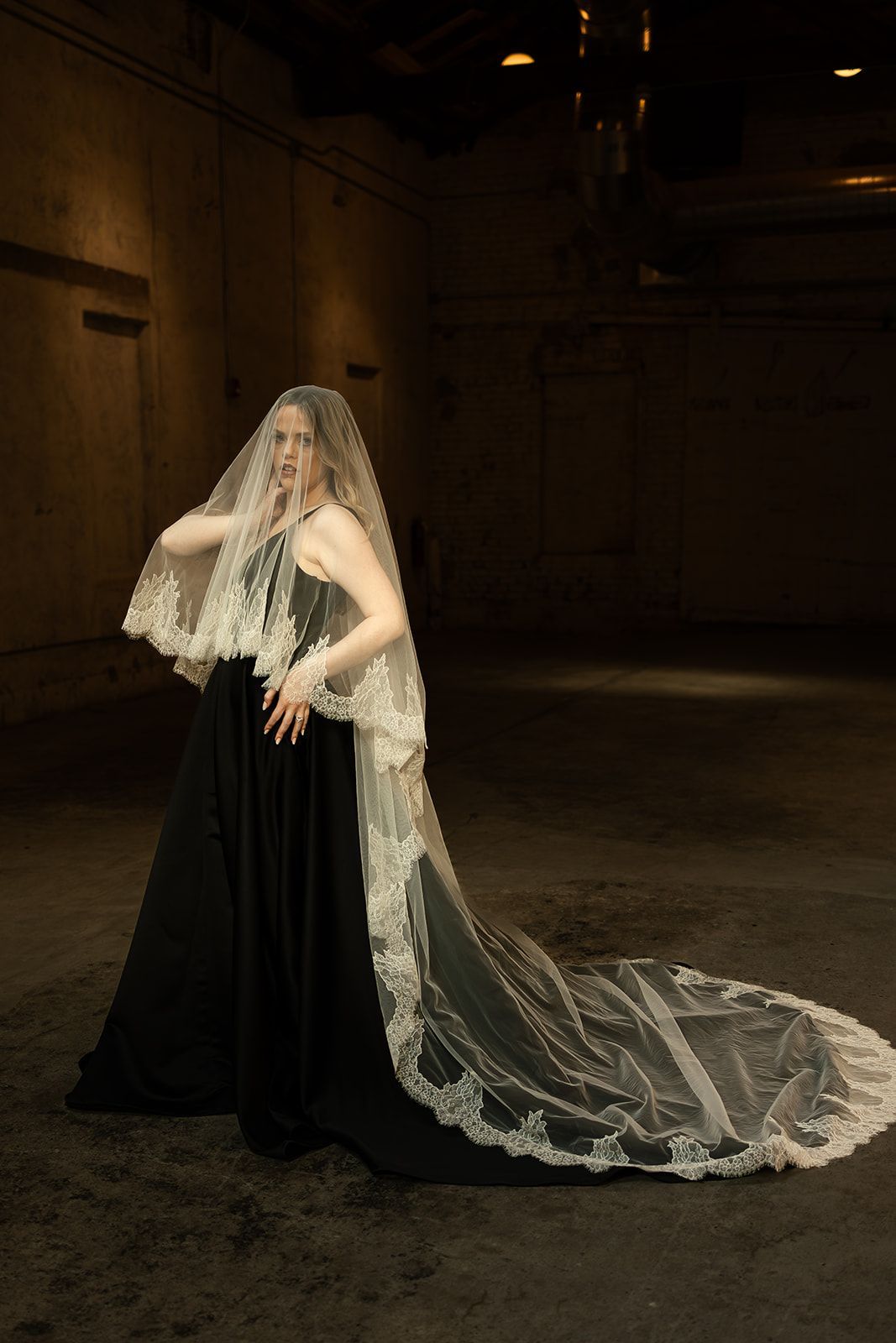 A woman in a wedding dress is standing next to a window.