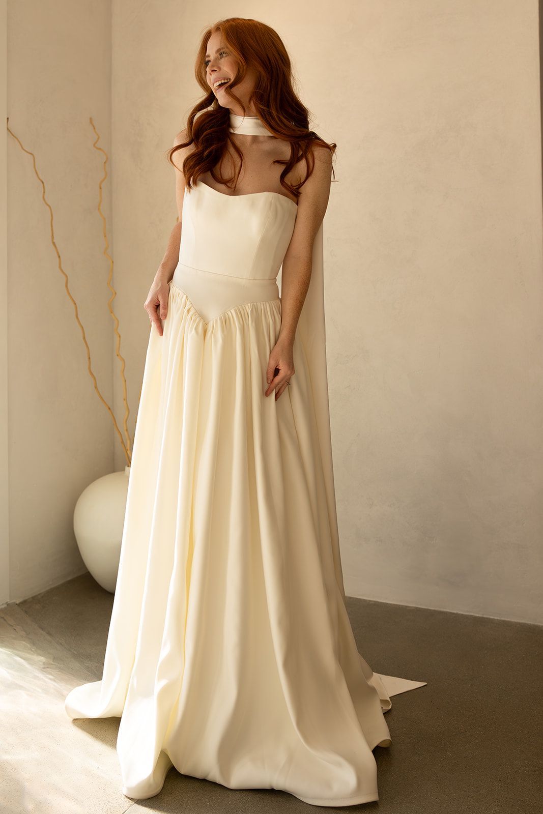 A room with two mannequins and a large mirror.