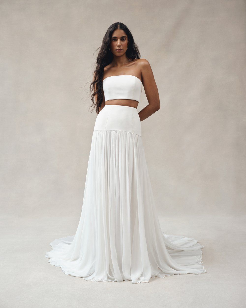 A two-part wedding dress with a fitted top and looser skirt