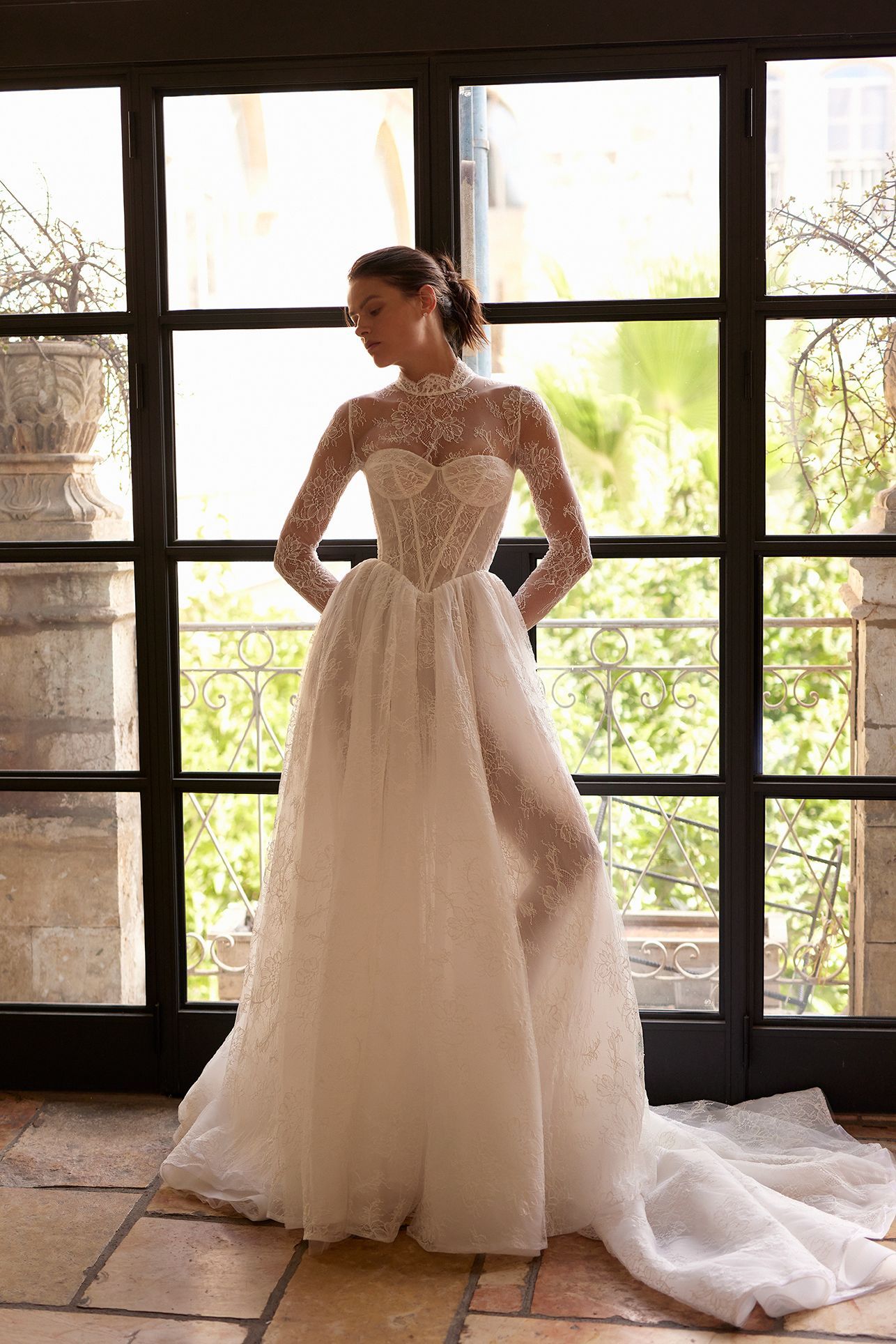 Gorgeous modern wedding gown with mesh lace sleeves and a corset-like bodice