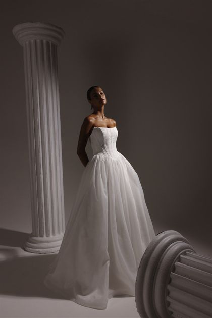 A black and white photo of two wedding dresses on mannequins.