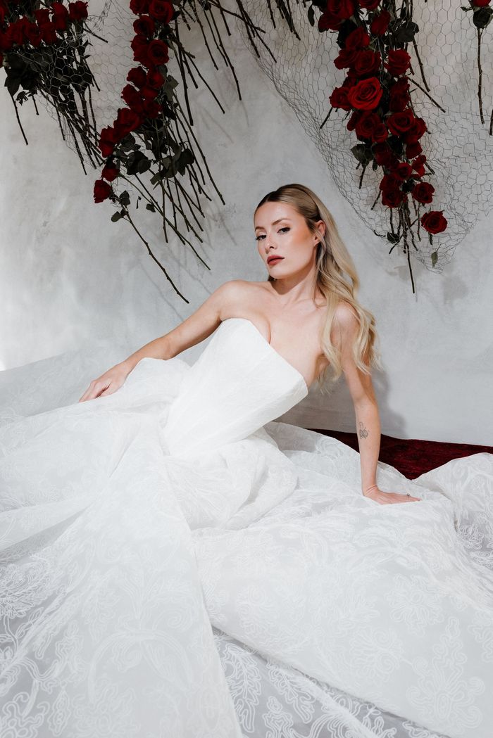 A bride posing in a gorgeous wedding gown with intricate gold beading details