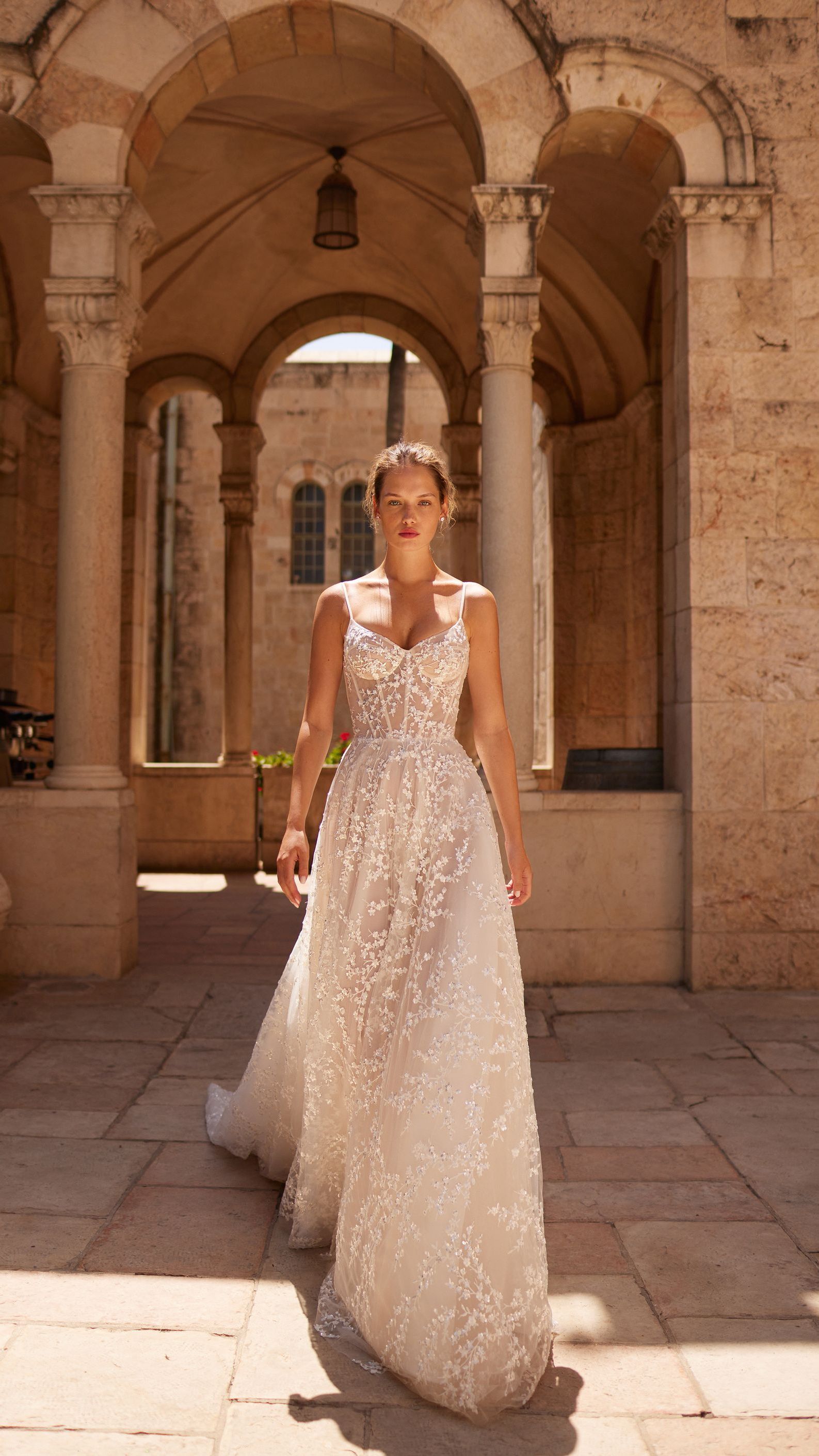 A woman in a wedding dress is standing in front of a building.