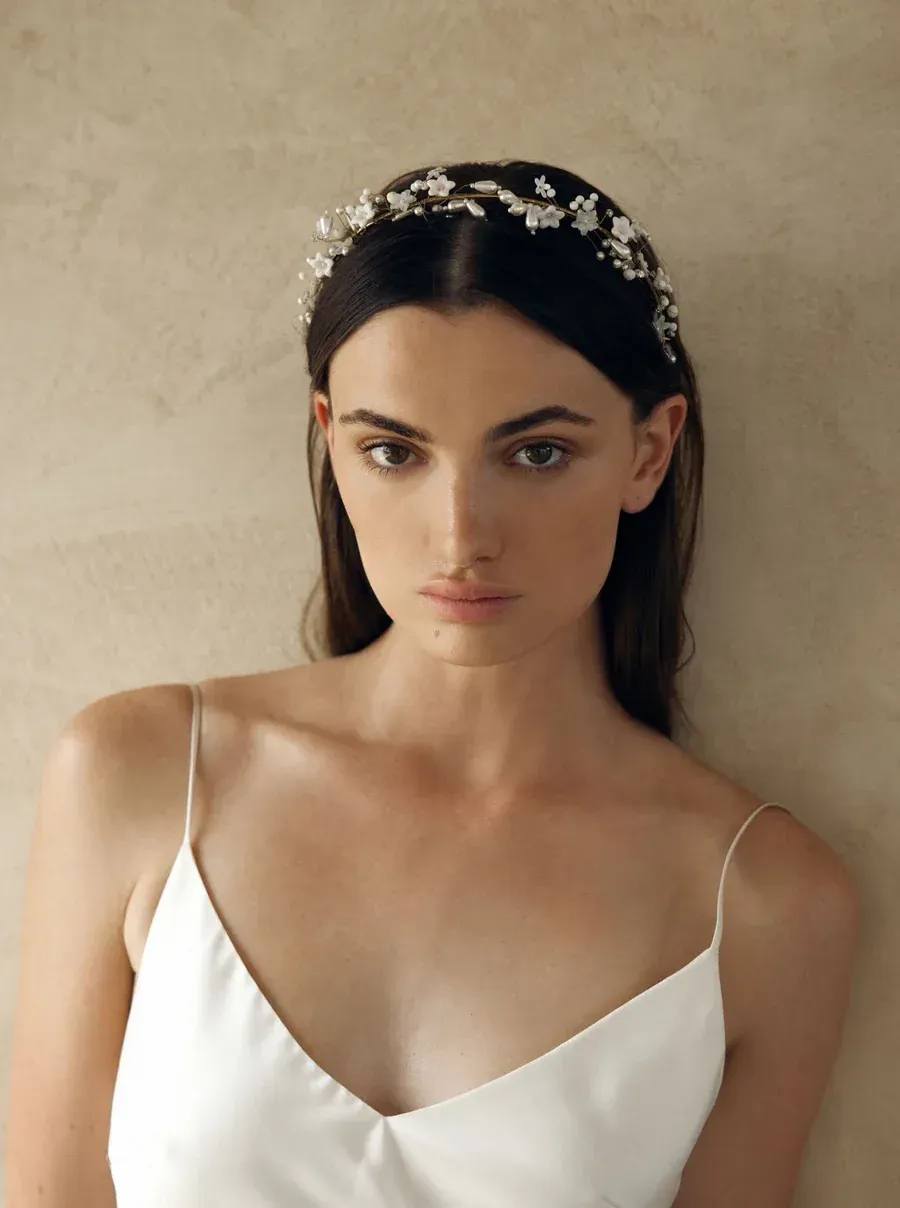 Close-up of a bride with a beaded headpiece and strappy wedding gown