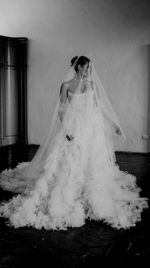 A black and white photo of a bride in a wedding dress and veil.