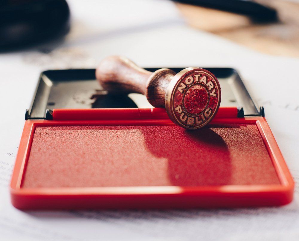 a notary public stamp is sitting on top of a red ink pad