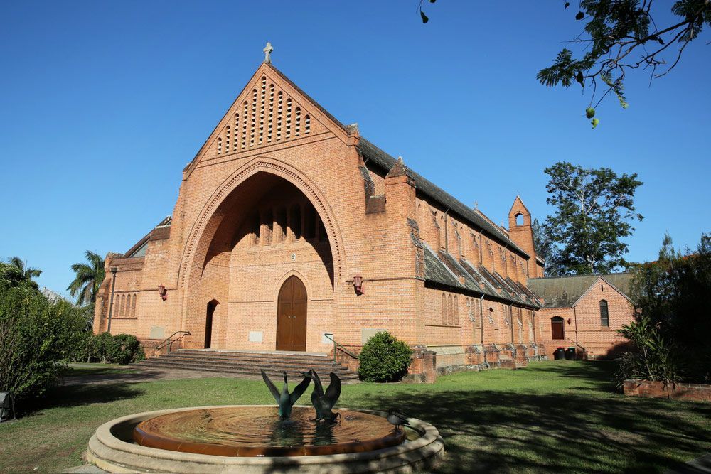 A Large Brick Church With A Fountain In Front Of It — Hilldrop Motor Inn In Waterview Heights, NSW