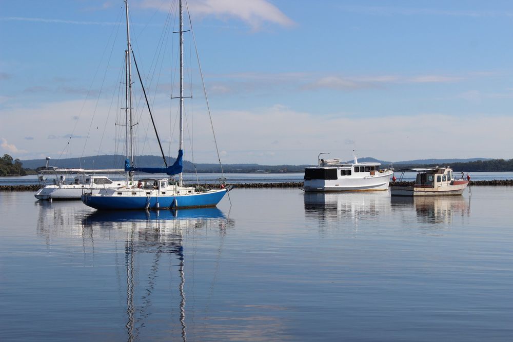 A Group Of Boats Are Docked In A Harbor On A Sunny Day — Hilldrop Motor Inn In Waterview Heights, NSW
