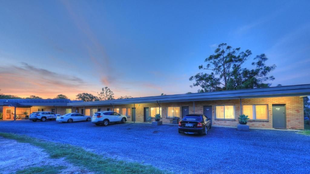 Motel With Cars Parked In Front Of It At Sunset — Hilldrop Motor Inn In Waterview Heights, NSW