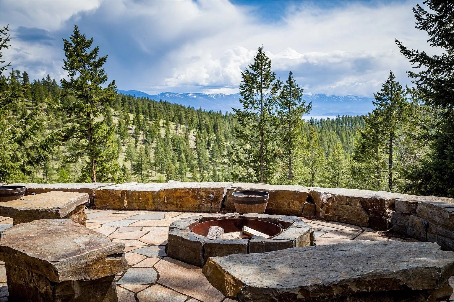 Stone firepit with mountain views, inviting outdoor gathering spot for guests at The Ridge lodge.