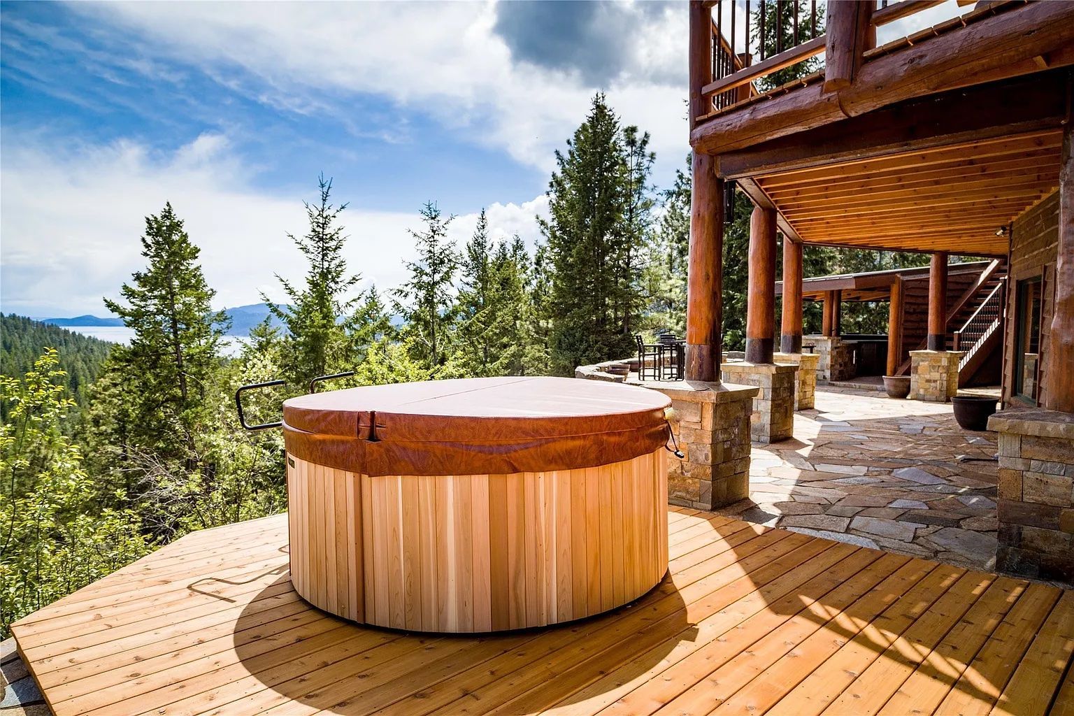 Wooden hot tub on deck with scenic mountain views, relaxing amenity for guests at The Ridge lodge vacation rental.