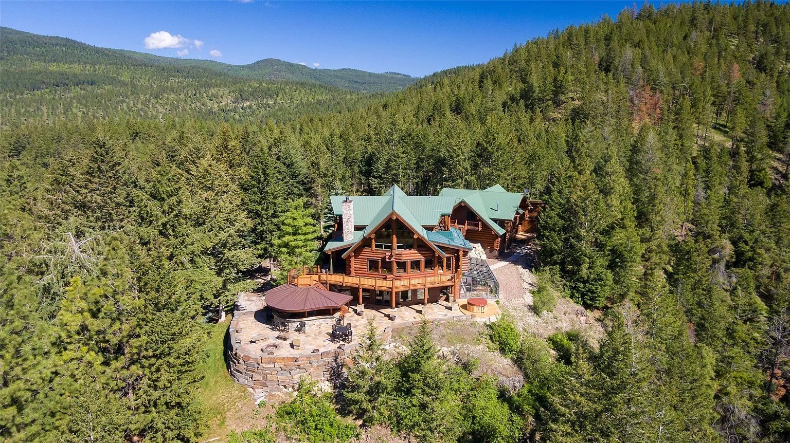 Aerial view of The Ridge lodge surrounded by forest, secluded vacation rental near Flathead Lake, Montana.