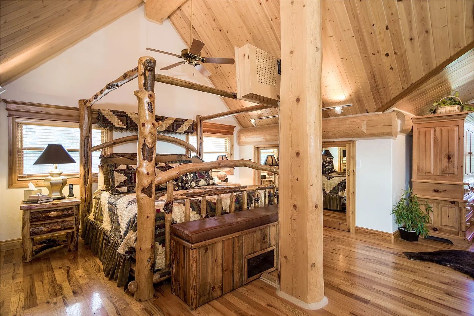 Master bedroom with rustic log bed frame, luxurious lodging at The Ridge lodge near Flathead Lake.