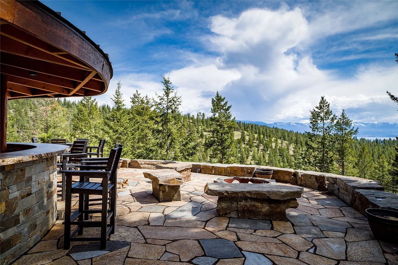 Stone firepit with scenic mountain views, outdoor gathering space at The Ridge at Flathead Lake.